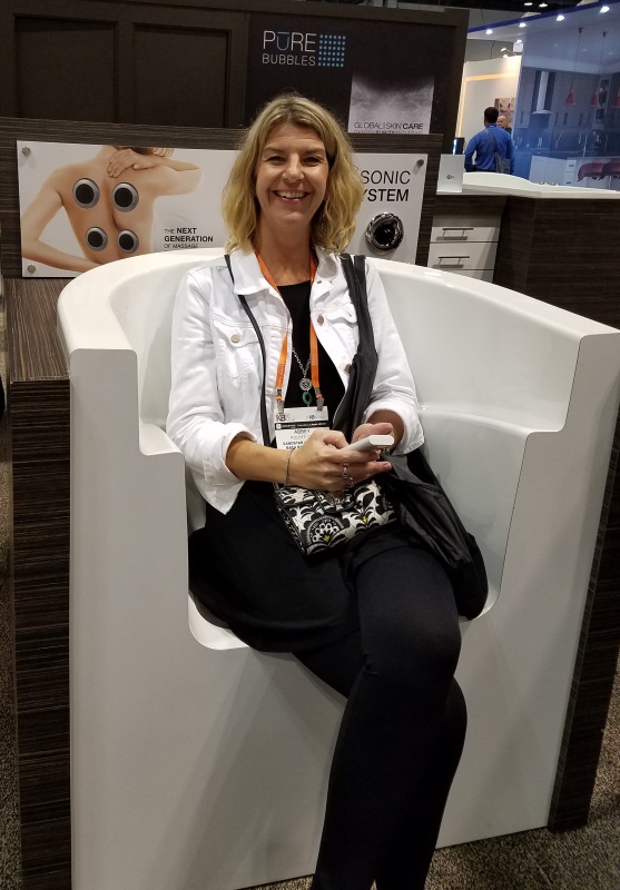 Abbey testing a massage chair at the 2017 Kitchen and Bath Industry Show